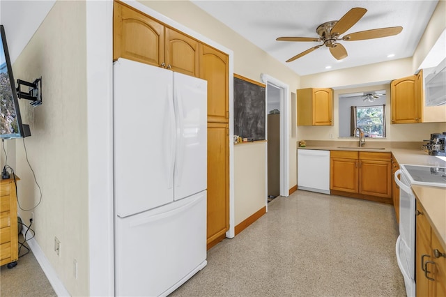 kitchen featuring recessed lighting, white appliances, a sink, baseboards, and light countertops