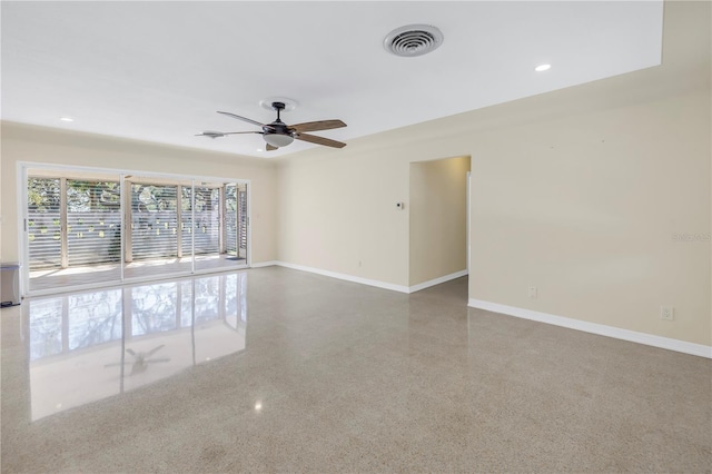 empty room featuring baseboards, visible vents, a ceiling fan, and speckled floor