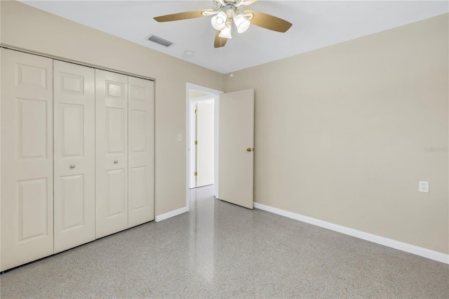 unfurnished bedroom with a closet, visible vents, ceiling fan, baseboards, and speckled floor