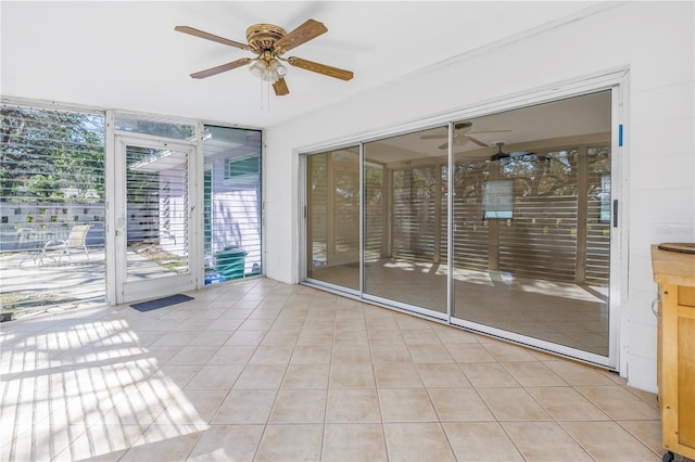 unfurnished sunroom with ceiling fan