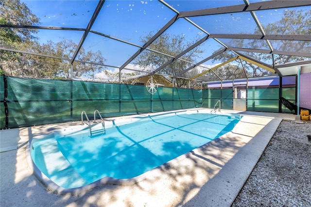 view of pool with glass enclosure and a patio