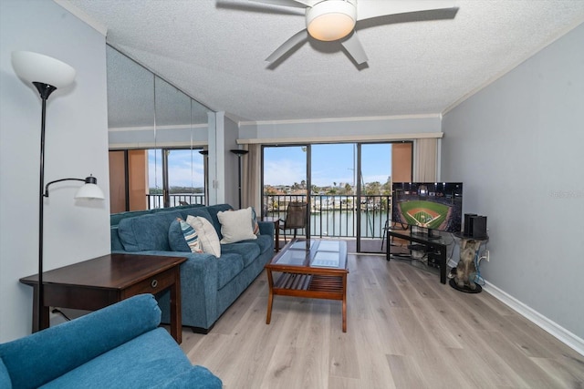 living room with crown molding, ceiling fan, a textured ceiling, and light hardwood / wood-style floors