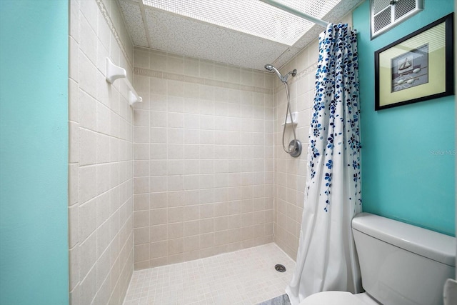 bathroom with a shower with curtain and toilet