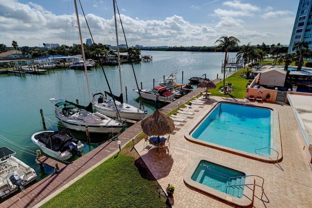 view of dock featuring a hot tub, a patio, and a water view