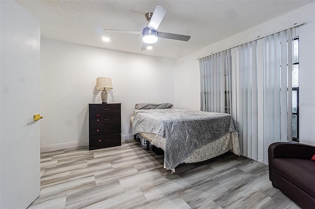 bedroom featuring ceiling fan, a textured ceiling, and light wood-type flooring