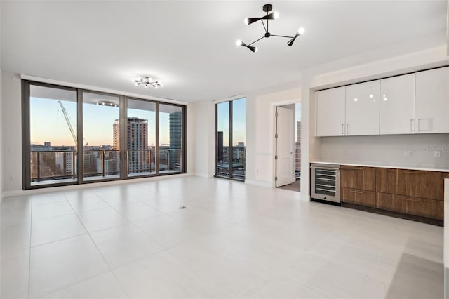 unfurnished living room featuring floor to ceiling windows and wine cooler