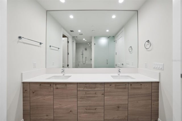 bathroom featuring a shower with shower door and vanity