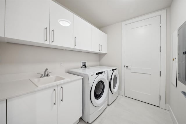 laundry area featuring sink, independent washer and dryer, and cabinets