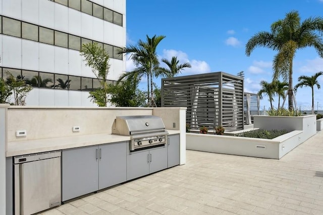 view of patio / terrace featuring an outdoor kitchen and a grill