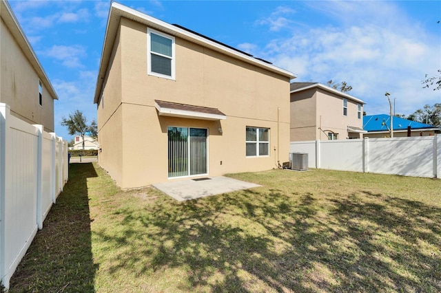 back of house featuring central air condition unit, a yard, a fenced backyard, and stucco siding