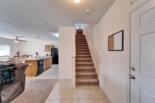 interior space featuring a textured ceiling, baseboards, a ceiling fan, and tile patterned floors