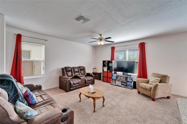 living room with light colored carpet, visible vents, ceiling fan, a textured ceiling, and baseboards