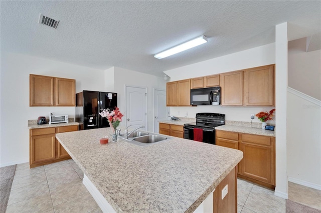 kitchen with visible vents, an island with sink, light countertops, black appliances, and a sink