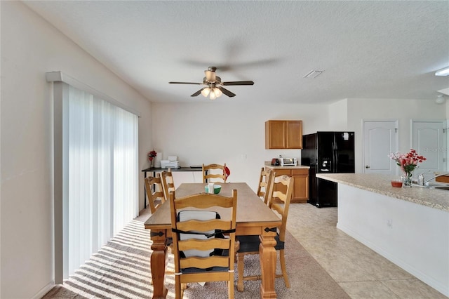 dining area with a textured ceiling, visible vents, and a ceiling fan