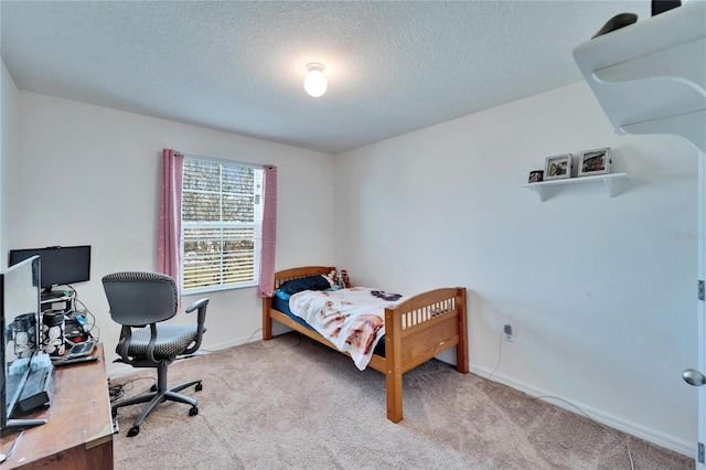 bedroom with light carpet, a textured ceiling, and baseboards