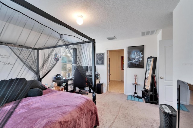 carpeted bedroom featuring a textured ceiling and visible vents