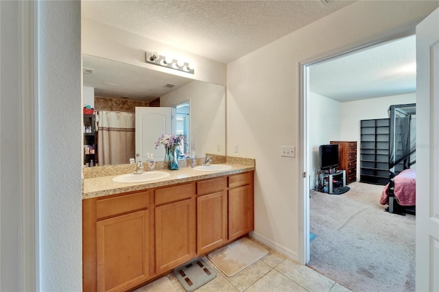 full bath featuring a sink, a textured ceiling, and double vanity