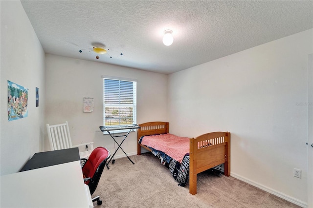 bedroom featuring baseboards, a textured ceiling, and light colored carpet