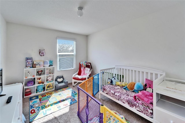 carpeted bedroom with a textured ceiling and baseboards