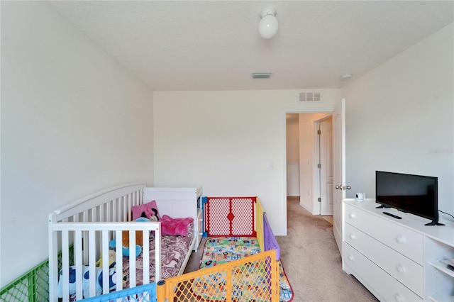 bedroom featuring visible vents, light carpet, and baseboards