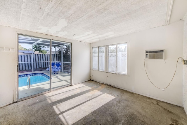 spare room with an AC wall unit and a healthy amount of sunlight