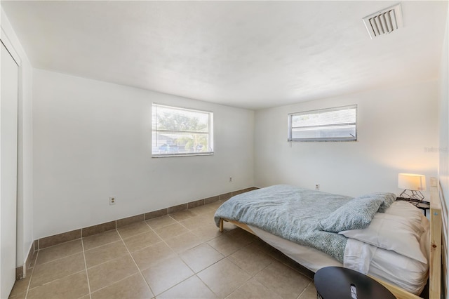 bedroom featuring light tile patterned flooring and multiple windows