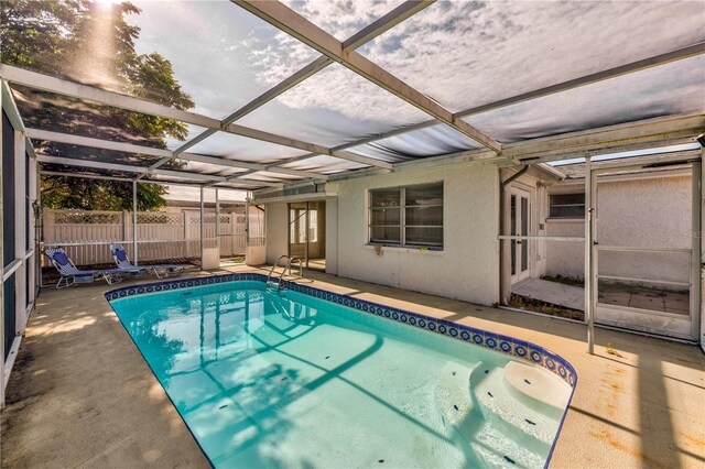 view of pool featuring glass enclosure and a patio area