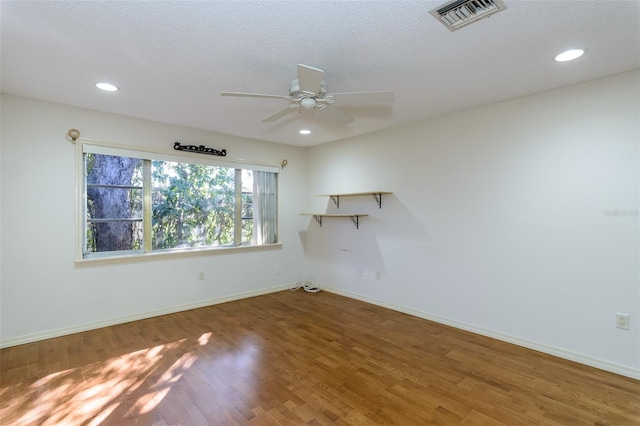 unfurnished room with ceiling fan, hardwood / wood-style flooring, and a textured ceiling