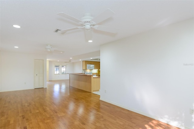 spare room featuring ceiling fan and light hardwood / wood-style flooring