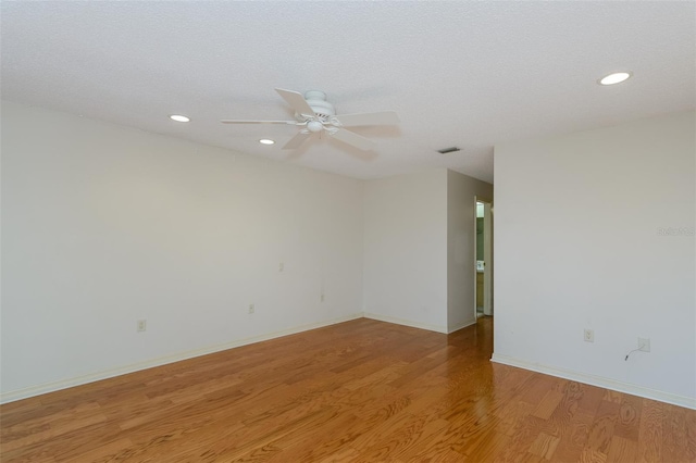 spare room featuring ceiling fan, a textured ceiling, and light hardwood / wood-style floors