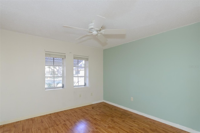 empty room with hardwood / wood-style flooring, ceiling fan, and a textured ceiling