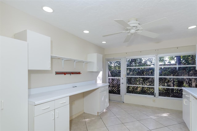 kitchen featuring built in desk, white cabinets, and light tile patterned flooring