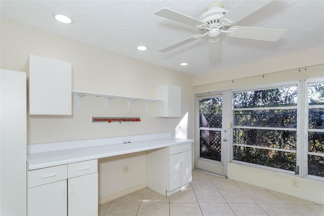 interior space featuring built in desk, light tile patterned floors, and white cabinets