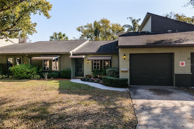 ranch-style home with a garage and a front lawn