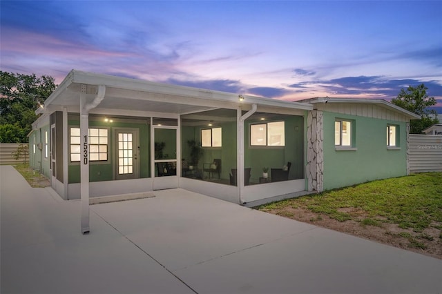 back house at dusk with french doors and a patio area