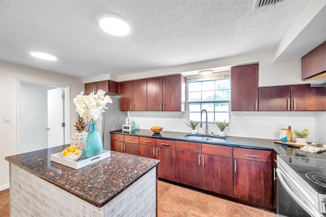 kitchen featuring a kitchen island, tasteful backsplash, sink, stainless steel range with electric cooktop, and a textured ceiling