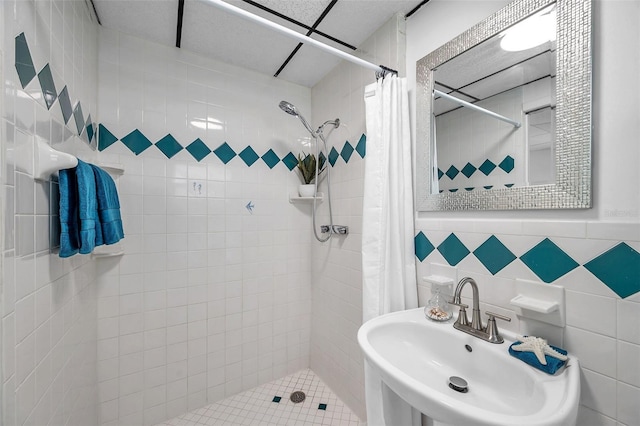 bathroom featuring tile walls, sink, and walk in shower