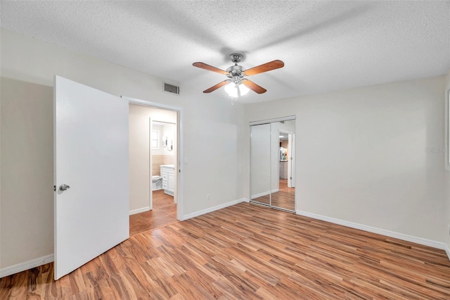 unfurnished bedroom with ceiling fan, light hardwood / wood-style floors, a closet, and a textured ceiling