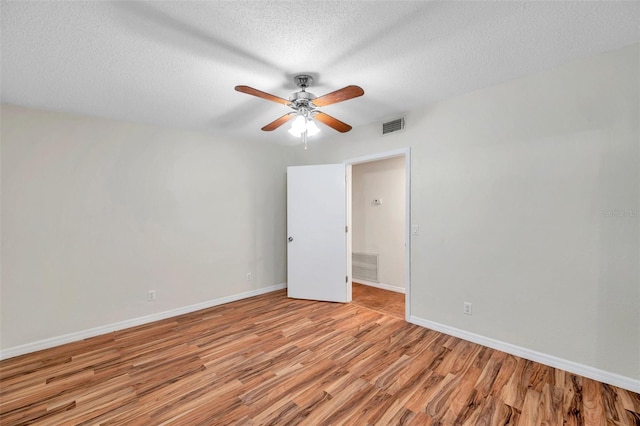 empty room featuring ceiling fan, a textured ceiling, and light wood-type flooring