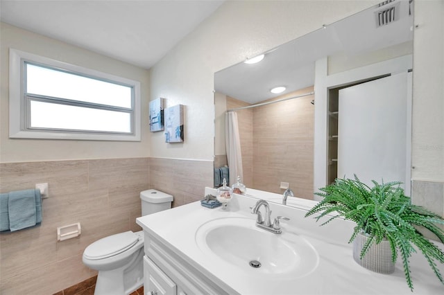 bathroom with vanity, tile walls, walk in shower, and toilet