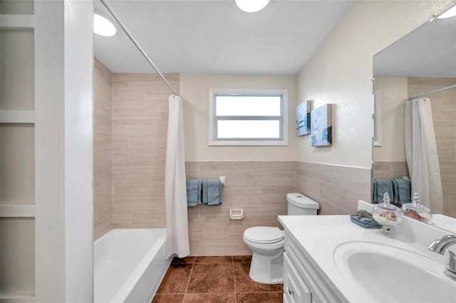 full bathroom with tile walls, shower / bath combination with curtain, vanity, toilet, and tile patterned floors