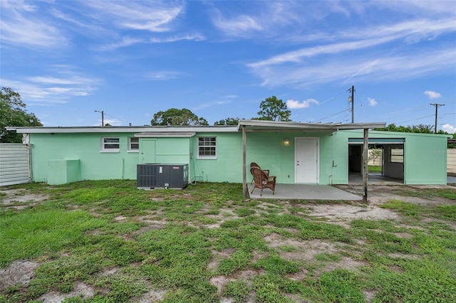 rear view of house featuring central AC unit, a yard, and a patio area