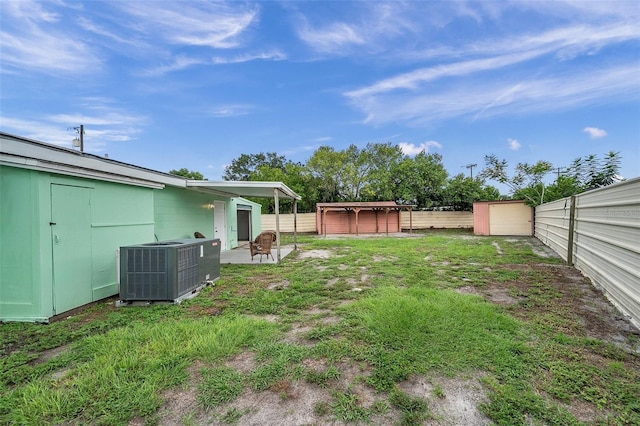 view of yard featuring central AC and a storage shed