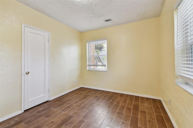 unfurnished room with a textured ceiling