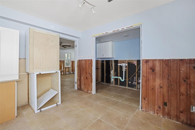 unfurnished room with light tile patterned floors and wooden walls