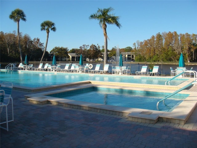 view of swimming pool with a community hot tub and a patio