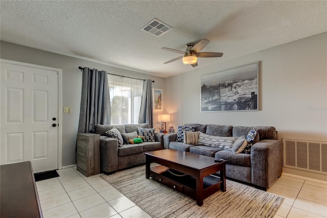 living room with light tile patterned floors, a textured ceiling, and ceiling fan