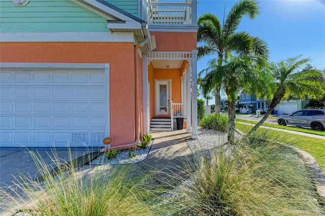 doorway to property featuring a garage and a balcony