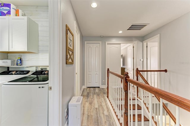 corridor featuring washing machine and clothes dryer and light hardwood / wood-style flooring