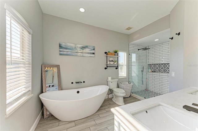 full bathroom featuring vanity, toilet, and separate shower and tub